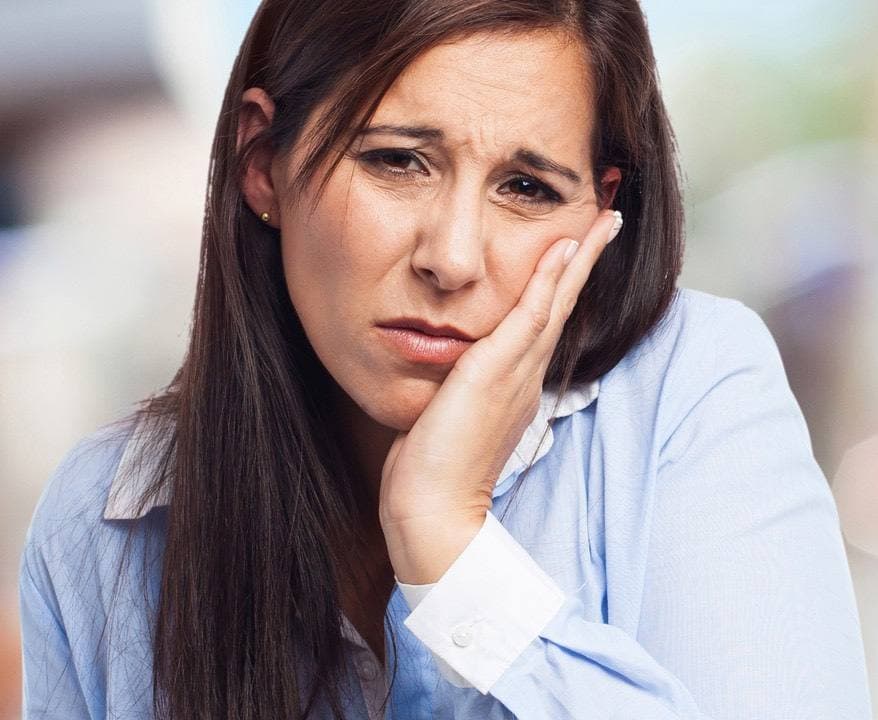 Woman holding her jaw with a toothache before an emergency dental visit in Fort Wayne